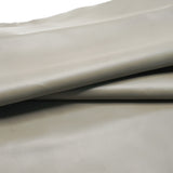 A close-up of draped light beige leather  with a smooth texture and soft shadows.