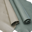 Two rolls of smooth leatherc, one in taupe-beige and the other in dusty sage green, shown on a white background.