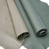 Two rolls of smooth leatherc, one in taupe-beige and the other in dusty sage green, shown on a white background.