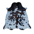 A natural cowhide rug with a black and brown spotted pattern on a white base, displayed flat against a solid white background.