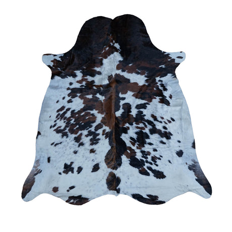 A natural cowhide rug with a black and brown spotted pattern on a white base, displayed flat against a solid white background.
