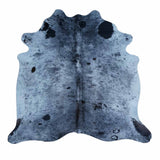 A natural cowhide rug with a blue-gray base and black spots, shown flat against a white background.