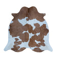 Brown and white cowhide rug with a natural spotted pattern, photographed flat against a solid white background.