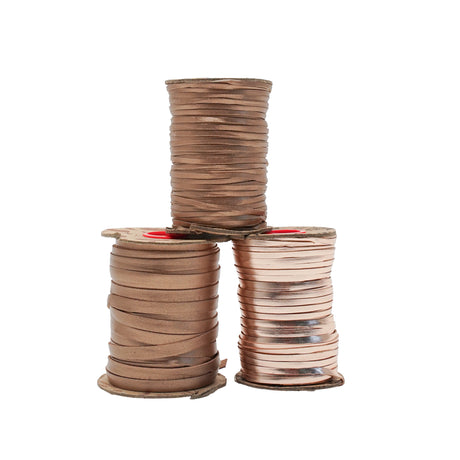 Three stacked spools of metallic copper-colored ribbon on a plain white background.
